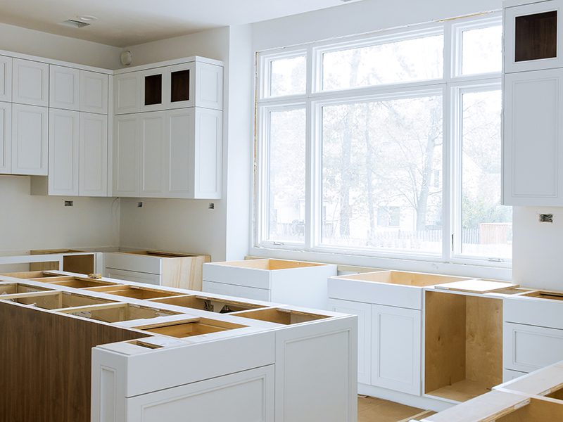 Wooden cabinets installation of in the white modular kitchen of installation base cabinets